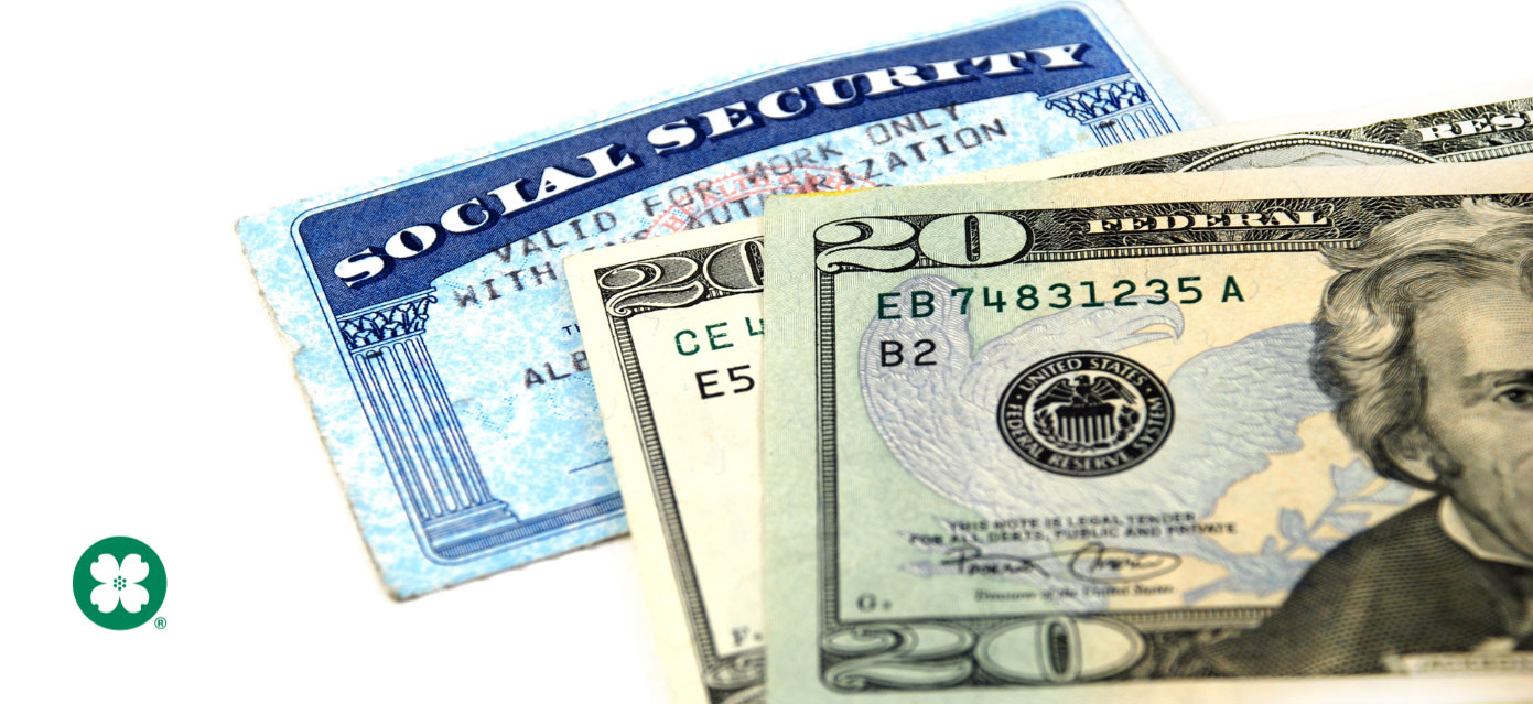 Social security card and folded dollar bills stacked