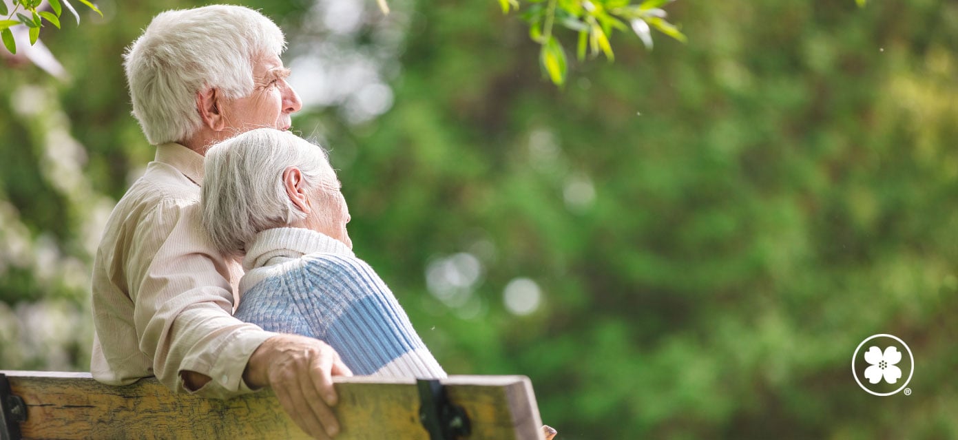 Aging couple sitting together on a bench