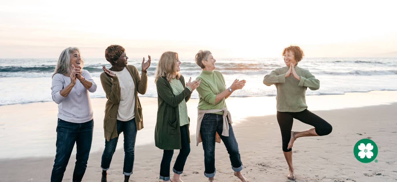 Group of retired women enjoying yoga on the beach