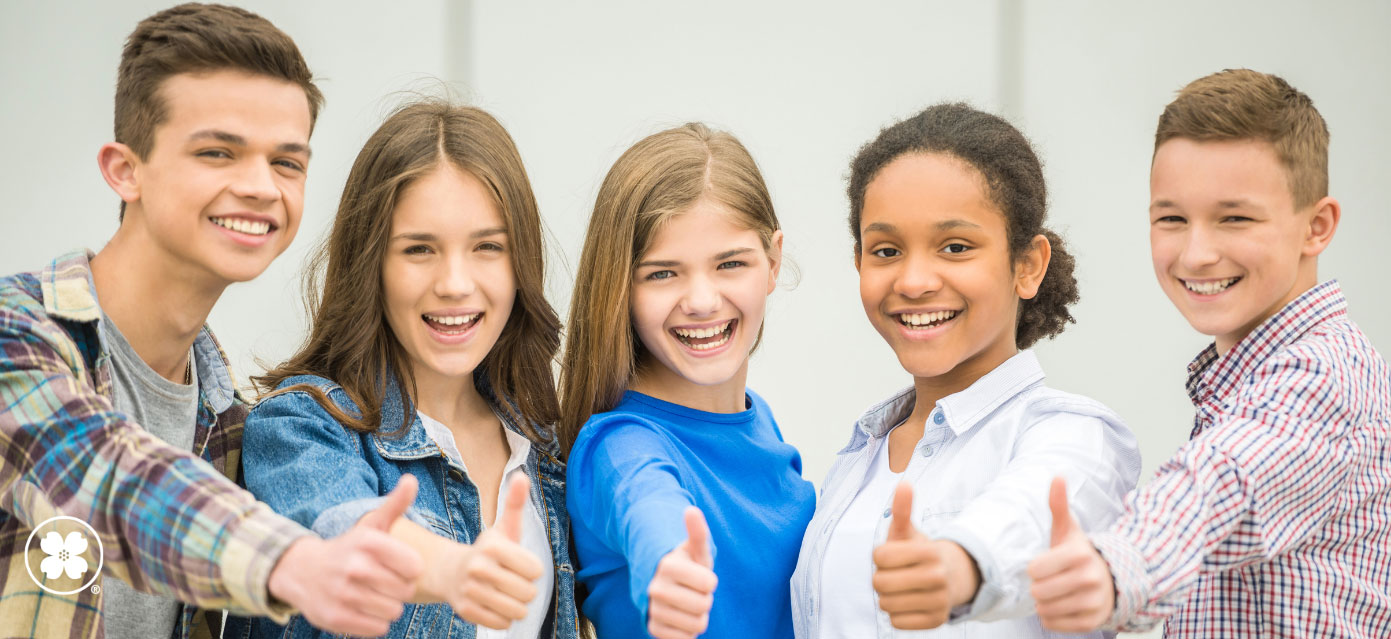 Group of young teenagers giving thumbs up sign