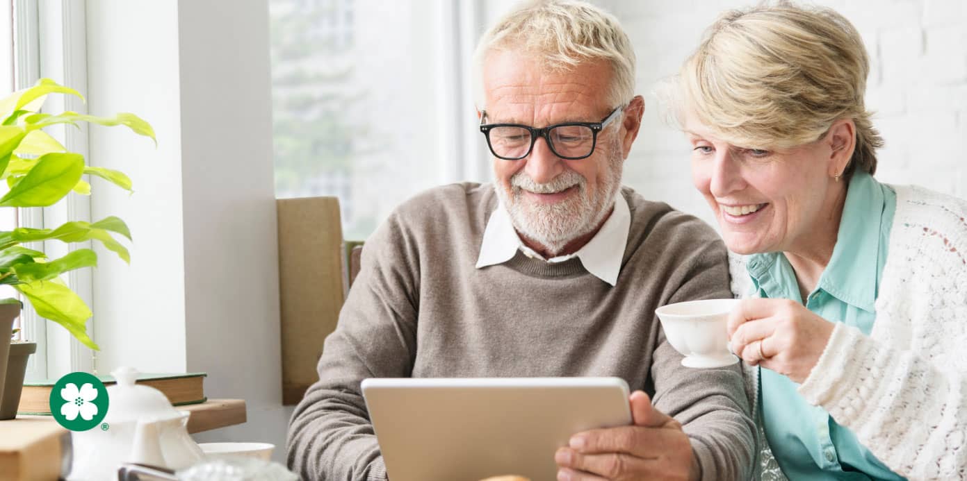 happy couple drinking coffee and looking at tablet