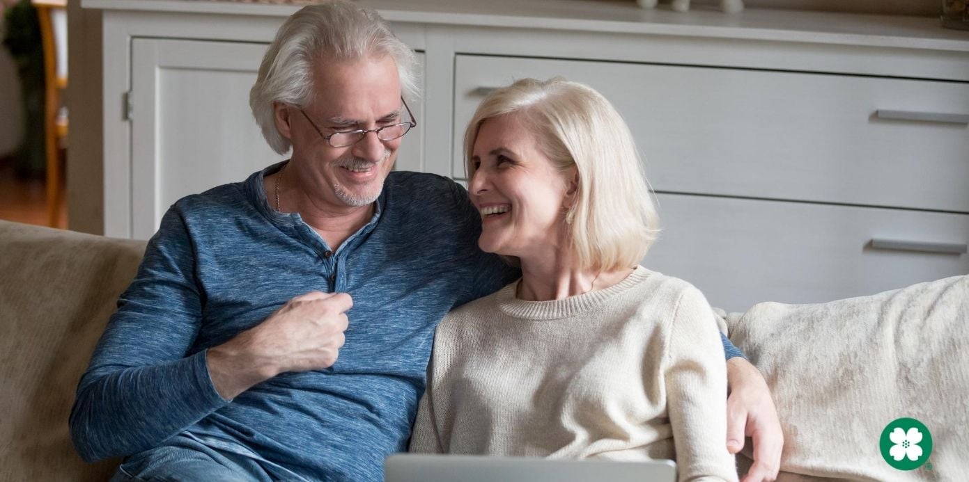 Retired couple laughing on a couch