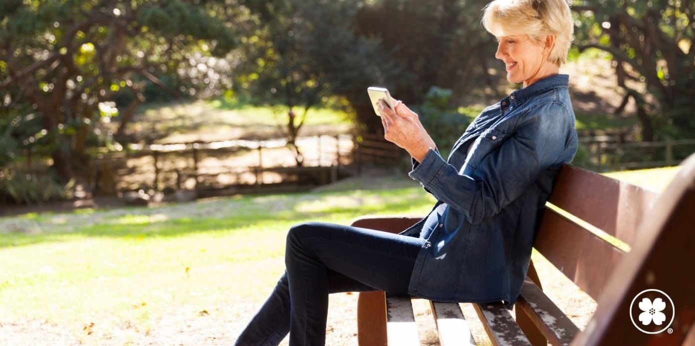 Lady sitting on a bench looking at her phone