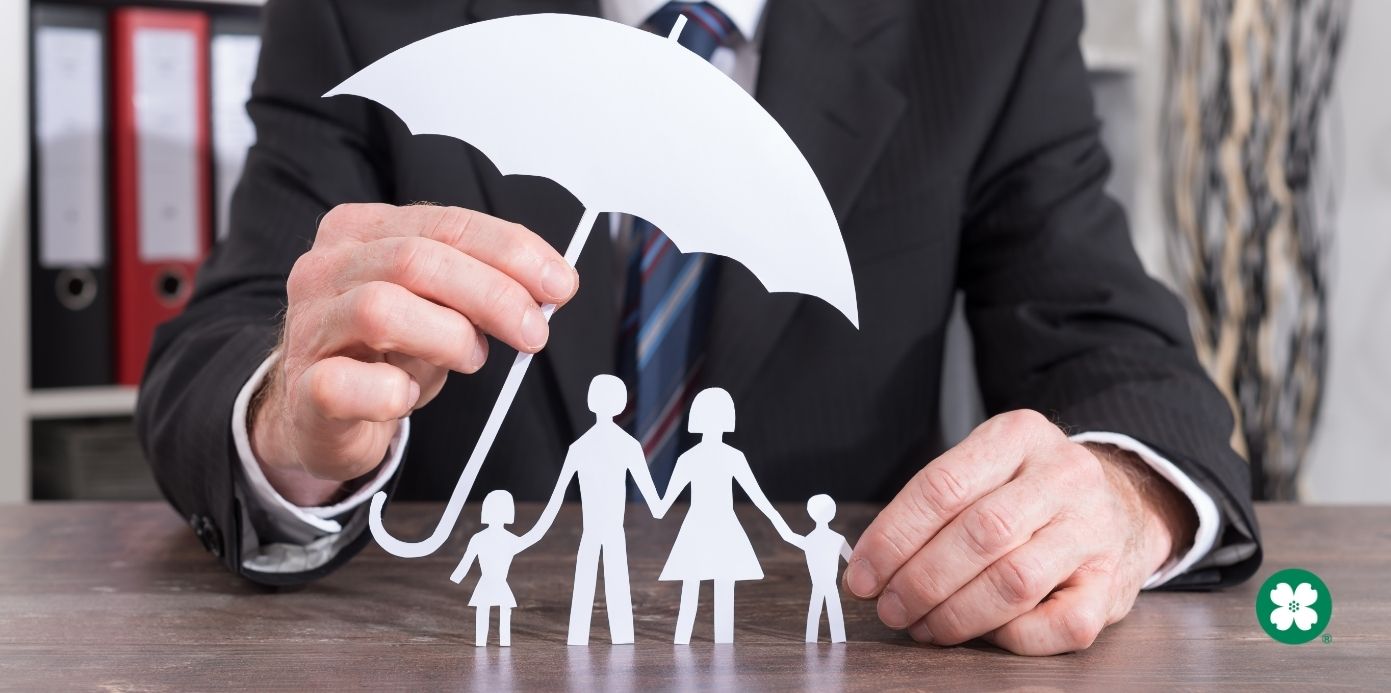 Man holding paper umbrella over a paper family