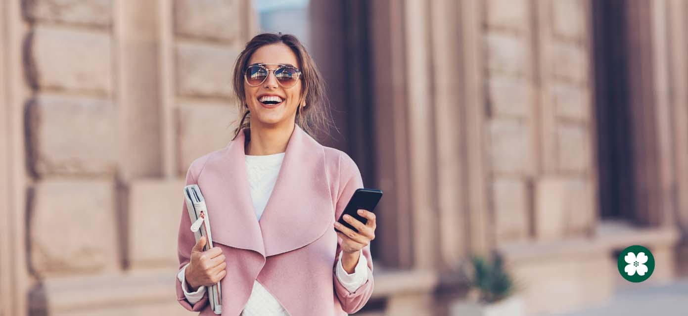 Affluent woman walking and holding phone