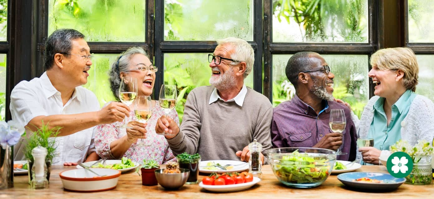 group of retirees enjoying meal and friendship while sitting at table