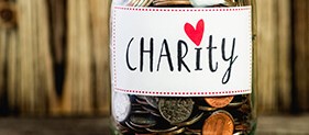 A jar with coins labeled "charity"